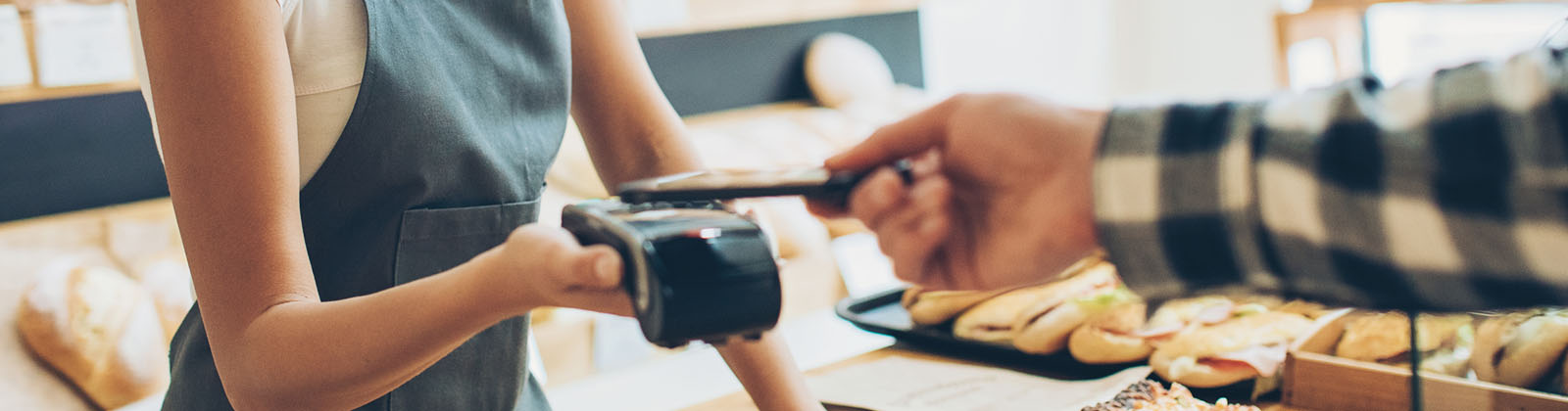 A person paying with their phone at a cafe